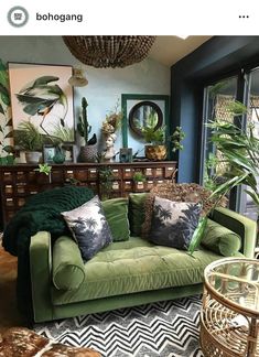 a living room filled with lots of green furniture and plants on top of the couch