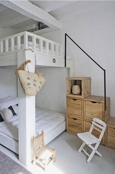 a white bunk bed sitting next to a wooden dresser