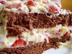 a piece of cake with strawberries and cream on top is sitting on a plate