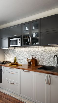 a kitchen with gray cabinets and wooden counter tops