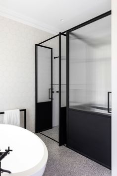 a white bath tub sitting next to a black and white shower stall in a bathroom