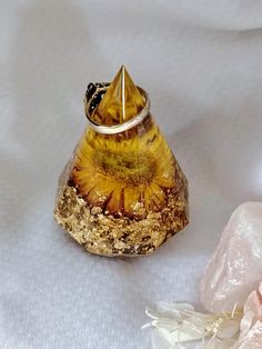 a yellow glass bottle sitting on top of a white tablecloth next to some rocks