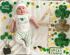 a baby is laying on a blanket with shamrocks around him and his name is lucky charm