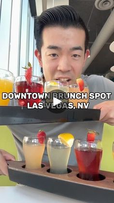 a man holding up a tray with drinks on it and the caption down town brunch spot las vegas, nv