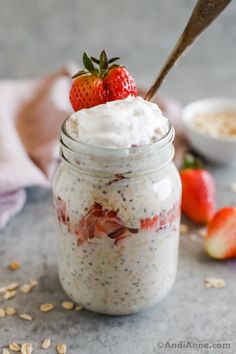 a jar filled with oatmeal and topped with a strawberry