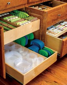 an open drawer in a kitchen filled with dishes