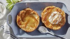 two baked desserts on a blue plate with spoon