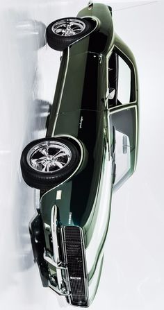 an old green car with black tires on it's rims is shown from above