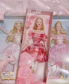 two barbie dolls in their packaging on a pink bed sheet with the same doll as it appears