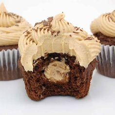 three cupcakes with frosting and chocolate sprinkles on white background