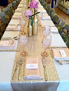 the table is set with pink flowers and place settings