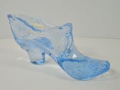 a glass shoe sitting on top of a white table