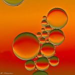 an image of soap bubbles floating in the air on a red and orange sky background