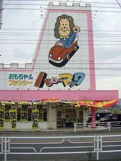 a large building with an advertisement on it's side next to a street in japan