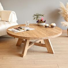 a wooden table sitting on top of a hard wood floor next to a white couch