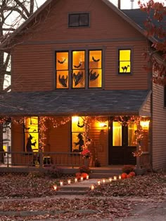 a house decorated for halloween with pumpkins and candles on the front porch is featured in an instagram