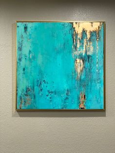 an abstract painting hangs on the wall in a room with white walls and blue paint