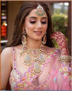 a woman wearing a pink outfit and jewelry