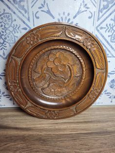 an ornate wooden plate on a wood table