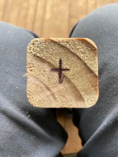 a person wearing blue pants with a wooden cross on it