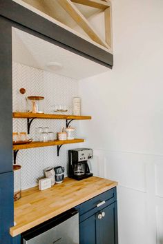 the kitchen counter is made out of wood and has shelves above it