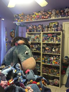 a large stuffed animal sitting on top of a bed in a room filled with toys