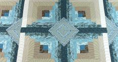 a blue and tan quilt with an intricate design on it's center piece,