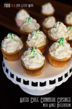 cupcakes with white frosting and green sprinkles on a plate