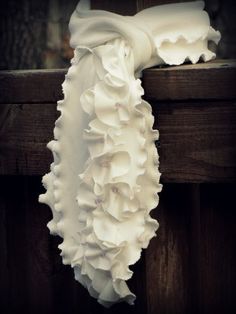 a white scarf hanging on the side of a wooden fence