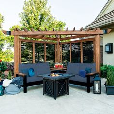 an outdoor living area with white couches and blue pillows on the patio, next to a pergolated gazebo