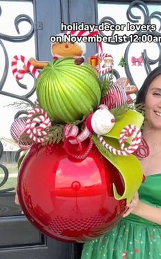 a woman in a green dress holding a large red vase