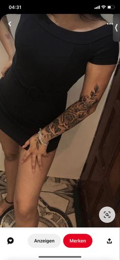 a woman with tattoos on her arm and leg is standing in front of a mirror