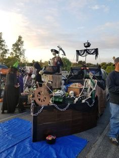 there is a pirate ship with skeletons on it and people standing around the boat in the background