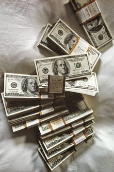 a pile of money sitting on top of a bed