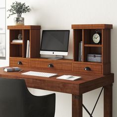 a wooden desk with a computer monitor and keyboard