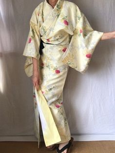 A pale yellow floral Kimono Robe. EXCELLENT Japanese vintage. Sash sold separately. Express ship included! PATTERN:  Floral. MATERIAL:  Synthetic.  Fully lined. COLOR:  Pale Yellow with pink, green, mustard, white and sage. CONDITION:  Used, vintage.  Great condition. Kimono are Dry Clean only. Kimono Sash & Obi Belt sold separately.  My shop: https://kimonomemoirsjp.etsy.com. SIZE: Woman's size LARGE Kimono. (Model is 5'7" wearing 1.5" platform sandal) Wingspan- 49.5 inch (126 cm) across the to Yellow Kimono, Japanese Dress, Vintage Japanese Kimono, Obi Belt, Womens Kimono, Japanese Vintage, Floral Kimono, Womens Robes, Japanese Kimono