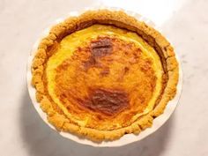 an overhead view of a baked pie on a white plate with a gray table top