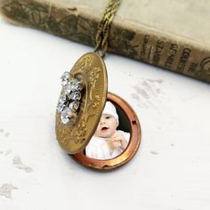 Vintage Locket with Rhinestone, Locket with Photos, Personalized Gift, Mothers Day Gift, Art Deco Necklace, Floral Engraved Locket A large vintage oval shaped locket that opens to hold 2 photos! Locket is a fabulous art deco style and has beautiful floral etching around the front. The locket is a gold colored brass. The inside is more copper. Opens to hold 2 photos that I can insert for you to make gift giving so easy! I added beautiful vintage rhinestone upcycled charm to the front.   Locket co Antique Rhinestone Necklace Gift, Antique Rhinestone Necklace For Gift, Victorian Rhinestone Jewelry Gift, Victorian Rhinestone Jewelry For Gifts, Locket Necklace Vintage, Large Locket, Vintage Rhinestone Earrings, Engraved Locket, Vintage Locket