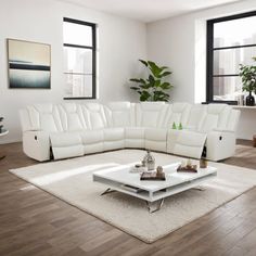 a living room with white furniture and large windows