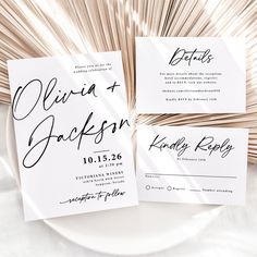 the wedding stationery is laid out on a white plate with palm fronds in the background