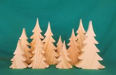 small wooden trees are lined up against a green background