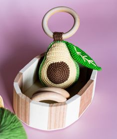 an avocado crochet toy in a wooden box