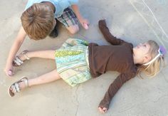 two children are laying on the ground with their shoes off and one child is holding something in his hand