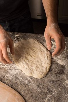 a person kneading dough on top of a counter