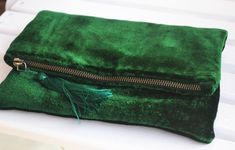 Buy emerald green fold over clutch. Handcrafted. Free Shipping Crafted from luxe emerald green velvet, this clutch folds over to make it compact and easy to carry. The satin lined interior has enough space for cell phone, keys and make up essentials. With an interior zip pocket, this is a smart and functional bag. Magnetic snap buttons for fold over. You can confidently gift this chic clutch to your girlfriend, mom, or even bridesmaids. —————————————————————————————————————This clutch can be cus Bridesmaid Purses, Avant Grade, Velvet Bags, Envelope Clutch Purse, Foldover Bag, Cheer Bag, Personalized Clutch, Emerald Green Velvet, Velvet Purse