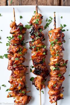 chicken skewers with cilantro and parsley on a white plate