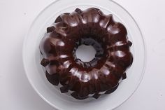 a chocolate bundt cake sitting on top of a white plate