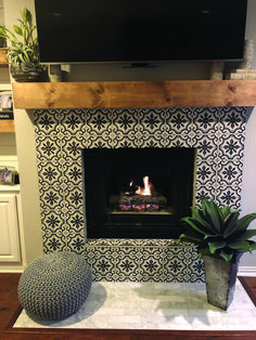 a fireplace with a television above it and a potted plant