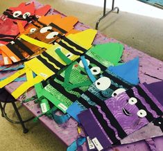 many different colored kites on a table with one being cut out to look like monsters