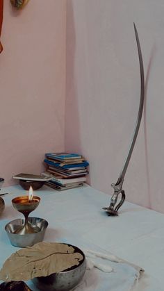 a table topped with bowls and candles on top of a white cloth covered tablecloth